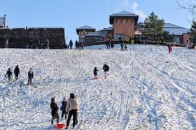 JANUARY 2021: Families enjoy the snow on the banking overlooking the Bogside. Photo: George Sweeney / Derry Journal. DER2104GS – 035