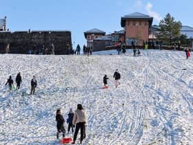 JANUARY 2021: Families enjoy the snow on the banking overlooking the Bogside. Photo: George Sweeney / Derry Journal. DER2104GS – 035