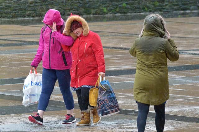 STORM BRENDAN 2020: People walking across Guildhall Square during the strong winds and rain brought by Storm Brendan back in 2020. DER0220GS – 007