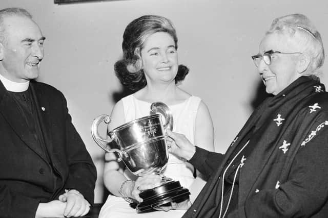 Cissie Parlour pictured centre showing the Bishop’s Cup she won in 1967 to her teacher and a founder of the feis Mrs Edward Henry O’Doherty. Dana recalled that the always glamourous Cissie was a star of the feis.