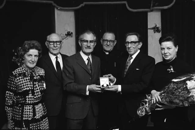 Redmond Friel, upon his retirement as principal of Waterside Boys' Primary School in June 1972, being presented with a gold watch by his successor Leo Day, at a function in the Castle Inn, Greencastle. Included, from left, are Kathleen Reid, vice-principal, Mr. J.D. Armstrong, management committee, Rev. J. Harkin, management committee, and Mrs. Sadie Friel.