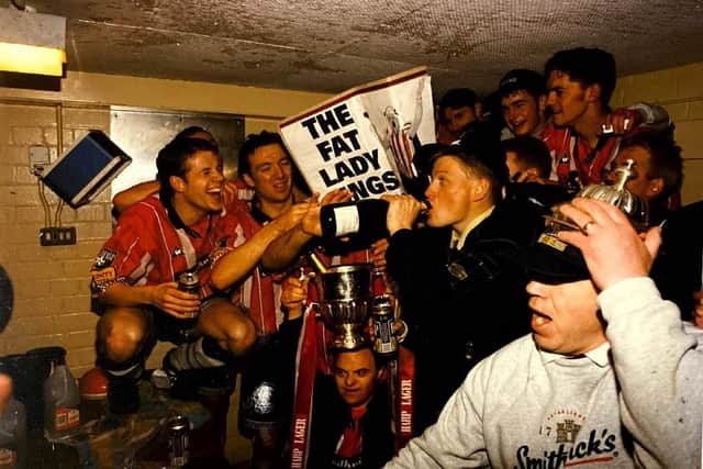 Derry City players celebrate in the dressing room after clinching the league title.