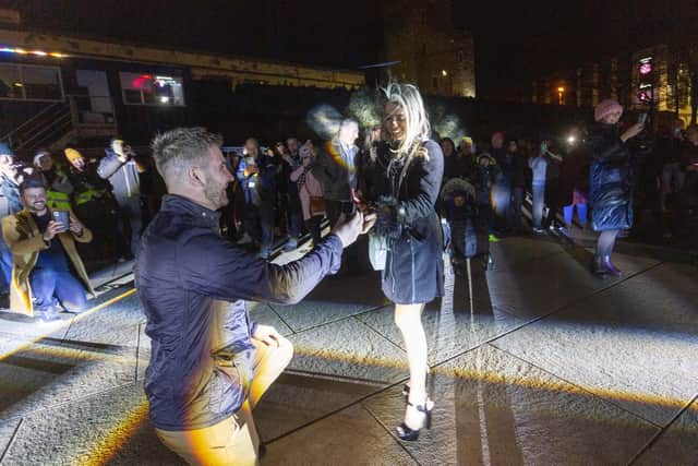 Benny Mamoin, from Newry, proposes to his girlfriend Mariane Freitas de Souza with the help of the projections onto the City's Guildhall during the Illuminate Festival. Photo Lorcan Doherty