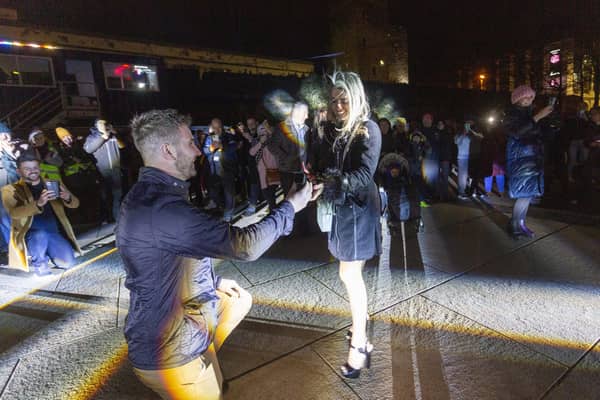Benny Mamoin, from Newry, proposes to his girlfriend Mariane Souza with the help of the projections onto the Cityâ€TMs Guildhall during the Luminate Festival.
Photo Lorcan Doherty