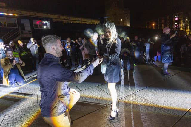 Benny Mamoin, from Newry, proposes to his girlfriend Mariane Freitas de Souza with the help of the projections onto the City's Guildhall during the Illuminate Festival. Photo Lorcan Doherty