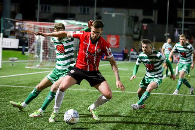 Patrick McEleney uses his strength to hold off Shamrock Rovers defenders.