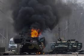 An armoured personnel carrier burns and damaged light utility vehicles stand abandoned after fighting in Kharkiv, Ukraine, Sunday, Feb. 27, 2022. The city authorities said that Ukrainian forces engaged in fighting with Russian troops that entered the country's second-largest city on Sunday. (AP Photo/Marienko Andrew)