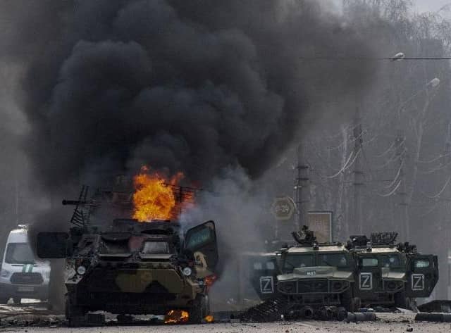 An armoured personnel carrier burns and damaged light utility vehicles stand abandoned after fighting in Kharkiv, Ukraine, Sunday, Feb. 27, 2022. The city authorities said that Ukrainian forces engaged in fighting with Russian troops that entered the country's second-largest city on Sunday. (AP Photo/Marienko Andrew)