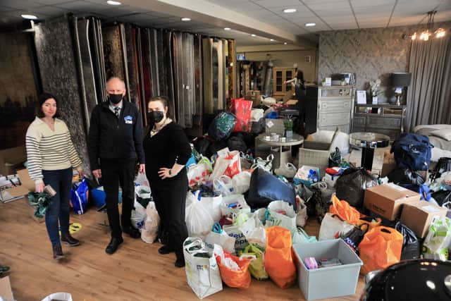 Volunteer Annie Heading, of the McGinnis Group, with Joe Barber and Michelle from CFC Interiors working through all the donations given for Ukrainian refugees.