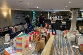 Claude's staff members at Christmas with some of the presents donated for the Christmas Appeal.