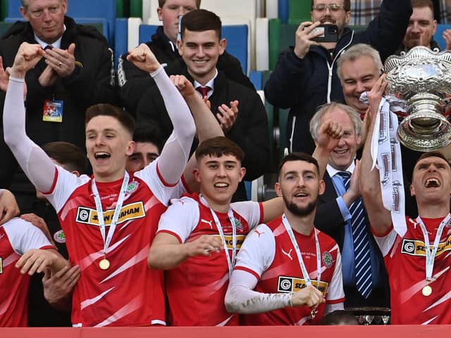 Cliftonville's Ryan Curran, Paul O'Neill and Jamie McDonagh celebrate as captain Chris Curran lifts the Bet McLean League Cup aloft. Picture by Colm Lenaghan/Pacemaker