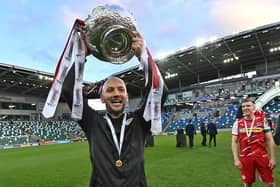 Cliftonville boss Paddy McLaughlin shows off the trophy to Reds supporters. Picture by Colm Lenaghan/Pacemaker