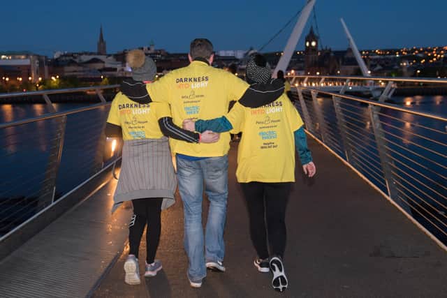 People walk across the Peace Bridge at Darkness Into Light 2019. Picture Martin McKeown.