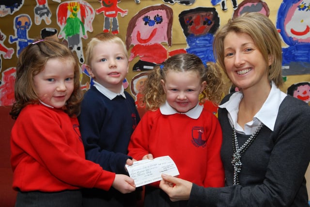 Lisnagelvin Primary School pupils, Zara Glenn, Jack Finlay and Katlyn Thompson, pictured handing over a cheque for £875.00, procceds from the annual harvest service at the school, to Linda Roulston. The funds will be used to build a new kitchen/canteen for the school at Galana, Kenya. LS43-111KM