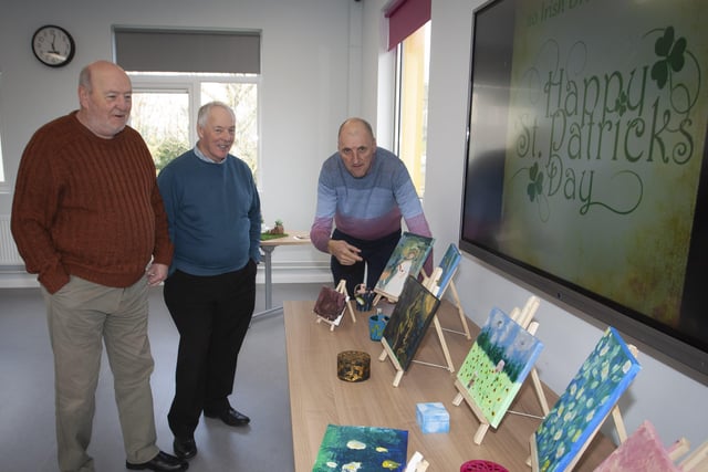 Alan Warke explains some of the artwork on display at the Cathedral Youth Club on St. Patrickâ€TMs Day to Mervy Shiels and Adrian Shiels.