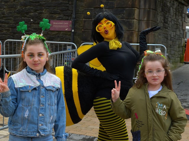 Bella-may McFadden and Mia Lynch pictured with a ‘Busy Bee’ during the St Patrick’s Day celebrations in the city. Photo: George Sweeney / Derry Journal. DER2211GS – 092