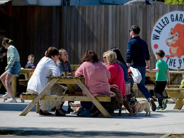 Customers enjoy a coffee in the sunshine, at St Columb’s House cafe, in St Columb’s Park. DER2120GS – 012
