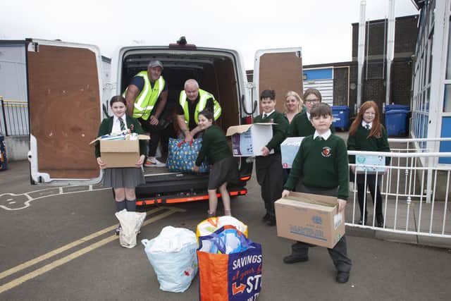 UKRAINE-BOUND. . . . .Drivers Sean Breen and Daniel Allen load the Ukraine-bound van on Tuesday morning with the help of pupils and staff at Greenhaw Primary School.