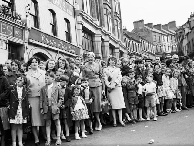 1958... Crowds gather as the Long Tower Carnival makes its way through Waterloo Place.