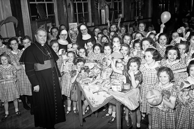 1955... Bishop Neil Farren pictured with children of Nazareth House, Bishop Street, to whom he distributed gifts at the conclusion of their annual Christmas entertainment. Included in picture are Rev Mother M William (on left) and Sister M Aiden.