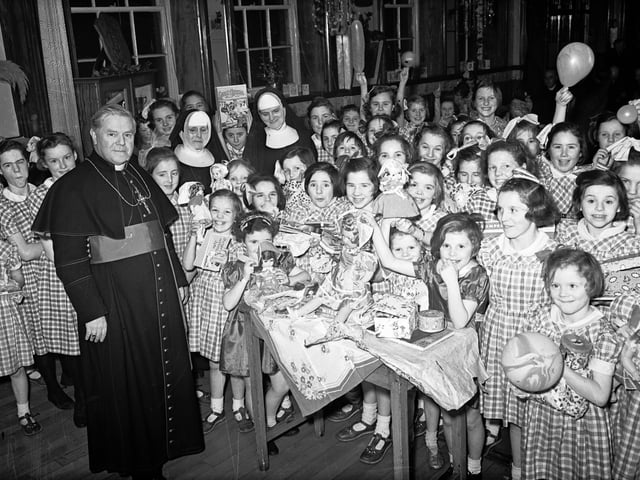 1955... Bishop Neil Farren pictured with children of Nazareth House, Bishop Street, to whom he distributed gifts at the conclusion of their annual Christmas entertainment. Included in picture are Rev Mother M William (on left) and Sister M Aiden.