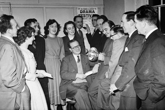 1957... Members of the St Columb's College Union Dramatic Society inspect the Dr Lyons' Cup, premier award at Cavan Drama Festival, which they won with their production of 'The Passing Day'. Seated centre is producer, Jack Gallagher, and the other members of the cast are, from left, Desmond Quinn, Dympna Armstrong, Joseph Gallagher, Evelyn McKeown, Marie Gillen, Frank McCrossan, Michael Gillen, Tony McKeown, James Quinn, John E Gallagher, Leonard Hume and William O'Doherty.
