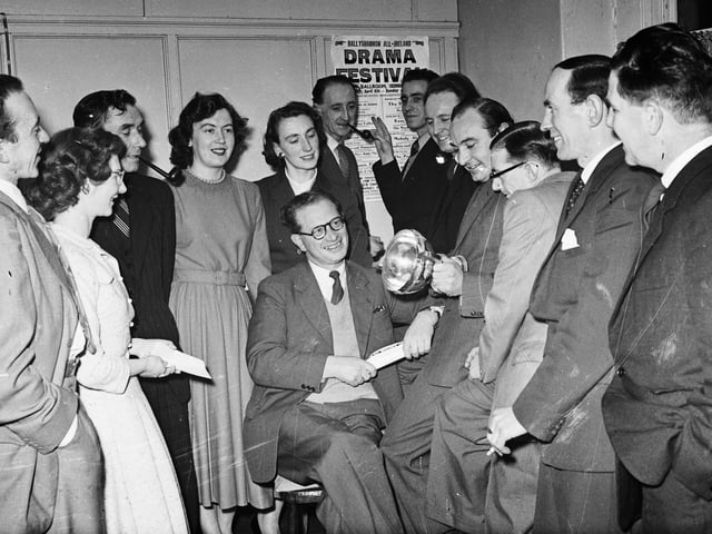 1957... Members of the St Columb's College Union Dramatic Society inspect the Dr Lyons' Cup, premier award at Cavan Drama Festival, which they won with their production of 'The Passing Day'. Seated centre is producer, Jack Gallagher, and the other members of the cast are, from left, Desmond Quinn, Dympna Armstrong, Joseph Gallagher, Evelyn McKeown, Marie Gillen, Frank McCrossan, Michael Gillen, Tony McKeown, James Quinn, John E Gallagher, Leonard Hume and William O'Doherty.