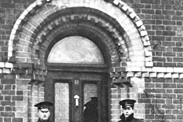 Police men outside the McMahon family home at Kinnaird Terrace in north central Belfast.