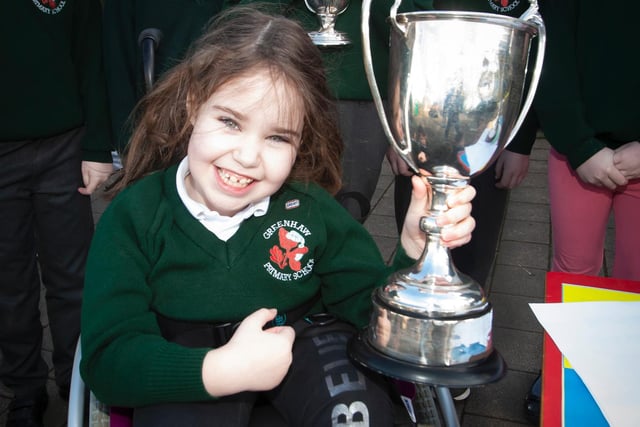 Greenhaw pupil Amelie Curran proudly pictured with one of the trophies during the visit by Steelstown player Donncha GIlmore recently. (Photo: Jim McCafferty)