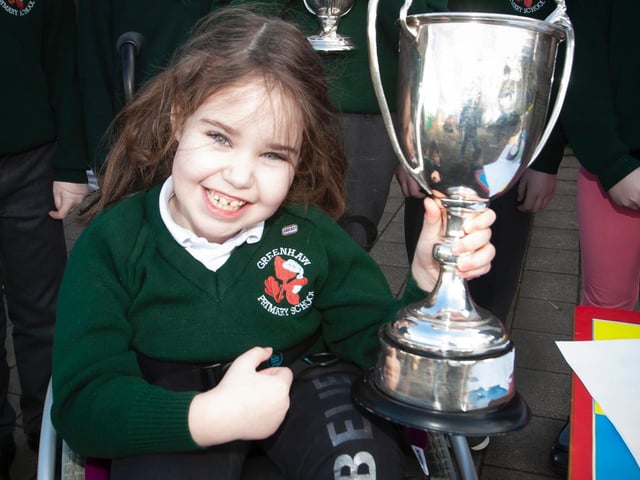 Greenhaw pupil Amelie Curran proudly pictured with one of the trophies during the visit by Steelstown player Donncha GIlmore recently. (Photo: Jim McCafferty)