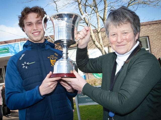 Ms. Heaney pictured with Steelstown Brian Ogs player and school coach, Donncha Gilmore and the All-Ireland trophy during the recent visit. (Photo: Jim McCafferty)