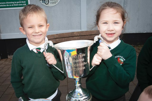 Charlie Harkin and Aoibheann Doherty proudly hold the All-Ireland Intermediate Club Championship trophy, the Kieran O'Sullivan Cup, at Greenhaw Primary School. (Photo: Jim McCafferty)