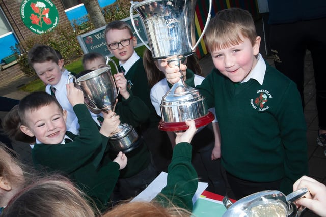 Some of the younger pupils get a chance to get their hands on the trophies who by Steelstown Brian Ogs last season during the recent visit (Photo: Jim McCafferty)