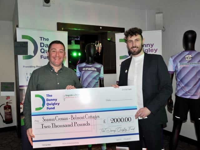 Danny Quigley presenting a cheque worth £2,000 to Seamus Crossan of Belmont Cottages.