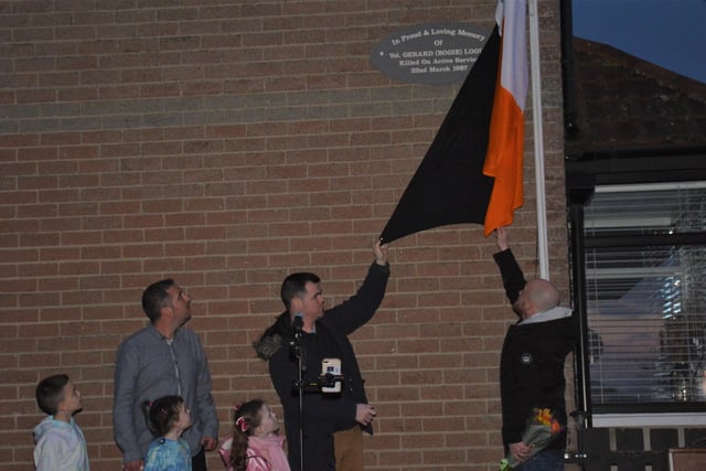 Tomás and Sean, sons of Gerard Logue, and grandchildren, unveil the new stone with Councillor Christopher Jackson.