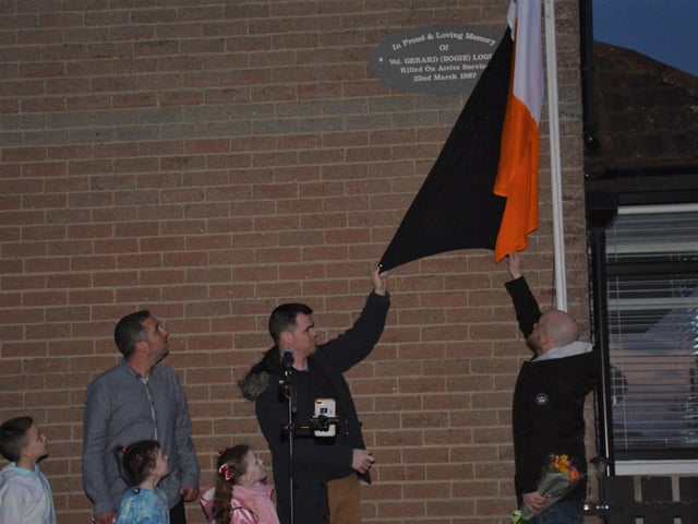 Tomás and Sean, sons of Gerard Logue, and grandchildren, unveil the new stone with Councillor Christopher Jackson.
