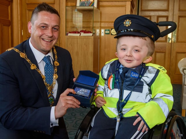 Jack Beattie from Donegal who has Osteogenesis Imperfacta or Brittle Bone Disease pictured during a reception held for him by Alderman Graham Warke, Mayor of Derry City and Strabane District Council. The honorary Garda also met with members of the PSNI who presented him with a certificate of recognition and the PSNI crest. Jack also made his first arrest in the North when he put the handcuffs on his dad Kevin.  Picture Martin McKeown. 30.03.22