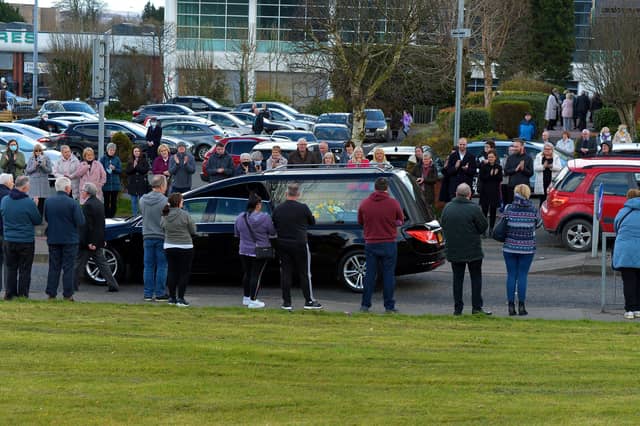 People applaud as the the hearse carrying the remains of Fr Paddy OKane leaves Holy Family Church on Thursday afternoon. Photograph: George Sweeney / Derry Journal. DER2213GS 042