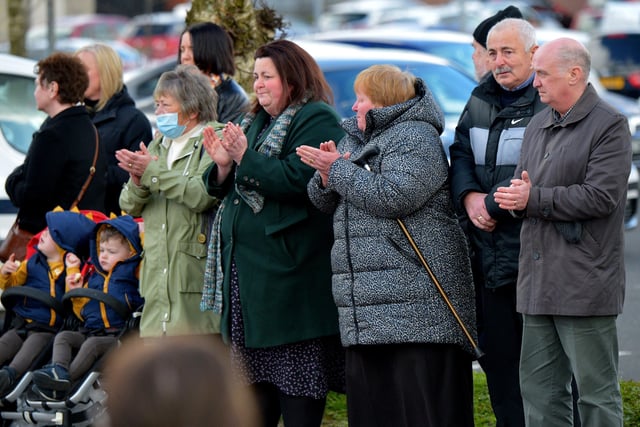 Local people applaud the hearse carrying the remains of Fr Paddy OKane as it leaves Holy Family Church on Thursday afternoon. Photograph: George Sweeney / Derry Journal. DER2213GS  043