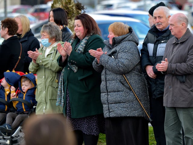 Local people applaud the hearse carrying the remains of Fr Paddy OKane as it leaves Holy Family Church on Thursday afternoon. Photograph: George Sweeney / Derry Journal. DER2213GS 043