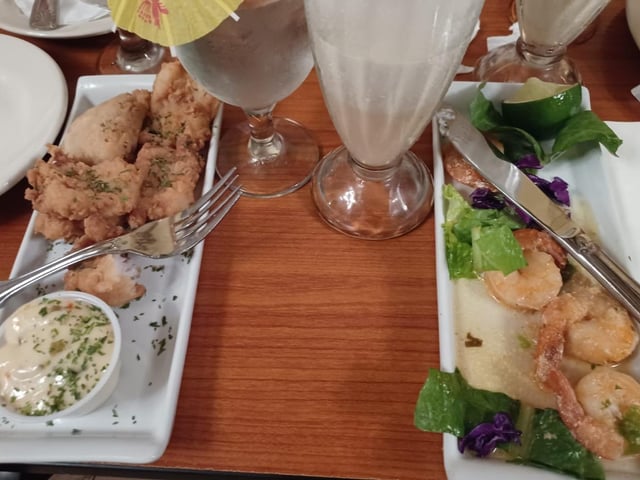 Shrimp sautéed in alioli and grouper fritters, breaded with coconut and served with pico de gallo and tartar sauce, washed down with Piña Colada in Barrachina, San Juan.