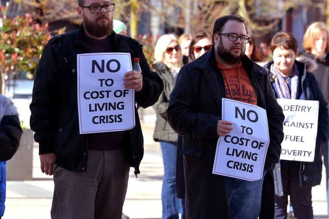 Colr. Doyle and other people hold posters at the Derry Fuel Poverty Rally in Waterloo Place on Sunday afternoon last. Photo: George Sweeney. DER2213GS – 067