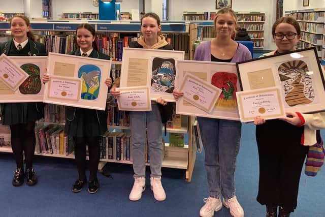 Pupils from St Cecilia’s College with their poems and lincouts by Ade Newton which are currently on display at the Central Library, Foyle Street, Derry.