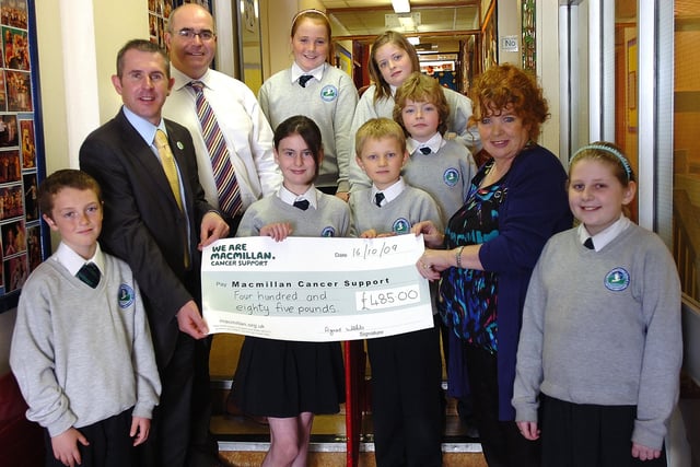 Pupils from Trench Road Primary School present Macmillan Cancer Support with a cheque for £485, proceeds of their world's biggest coffee morning event. Included are Paul Sweeney, Macmillan Cancer Support, Brendan Bradley, principal, and Agnes Webb, teacher. (2010PG13)