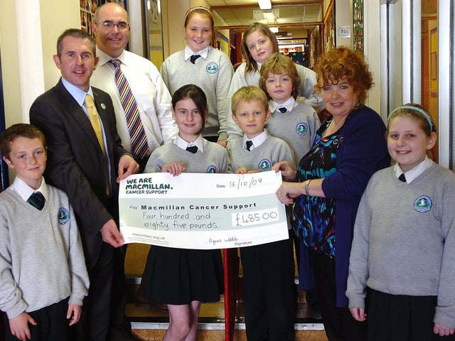 Pupils from Trench Road Primary School present Macmillan Cancer Support with a cheque for £485, proceeds of their world's biggest coffee morning event. Included are Paul Sweeney, Macmillan Cancer Support, Brendan Bradley, principal, and Agnes Webb, teacher. (2010PG13)