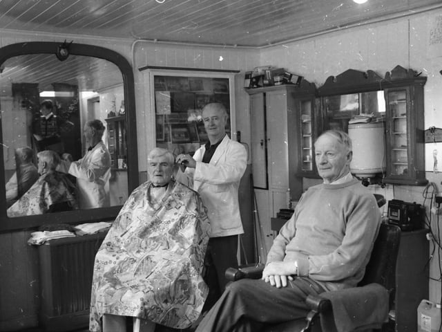 Mr. Paddy Harkin attending to customers at his barber shop in Moville.