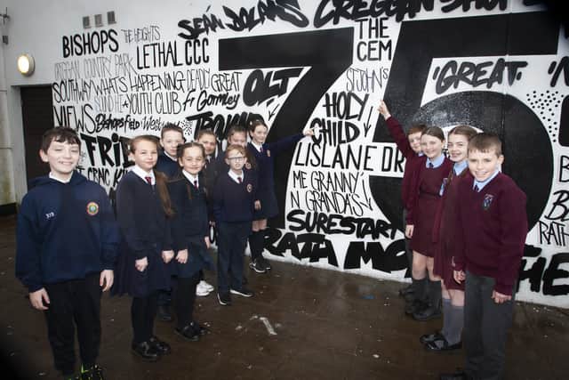 WEâ€TMRE ON IT!. . . .Children from Holy Child PS and St. Johnâ€TMs PS identify their names on the new mural on Monday.