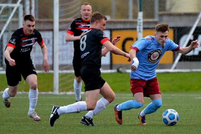 Institute’s Jamie Dunne gets to the ball ahead of Ballyclare Comrades' Ashton McDermott. Picture by George Sweeney.