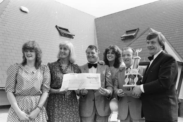 A new trophy and cheque to sponsor the ‘Miss Derry’ competition due to be held in The Venue. Mr. Ron Desmond, right, donor of the trophy, makes the presentation to Mr. Michael Deery. Mrs. Margo Duddy, second from left, presents a cheque on behalf of the sponsors, Foster’s, Strand Road, to Mr. Patsy Glenn, director of Gate House Promotions who are staging the competition. On left is Paula Duddy, manageress of The Venue, and third from right is Geraldine McGrory, holder of the ‘Miss Derry’ title, who went on to win the ‘Miss Ireland’ crown and took part in the ‘Miss World’ finals in London.
