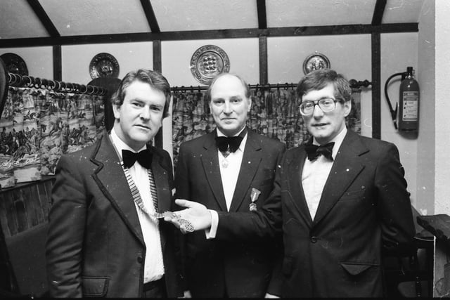 Outgoing chairman of the Derry Round Table Mr. Campbel Bolton investing the newly elected chairman Mr. Michael Moore, with the chain of office at the annual general meeting held in The Happy Landing, Eglinton. In the centre is Round Table president Dr. Harry Leitch.